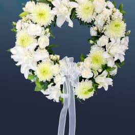 Heart-shaped white floral wreath with a ribbon bow