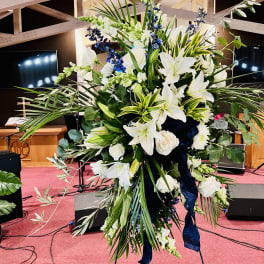 Large white and blue floral standing arrangement on an easel