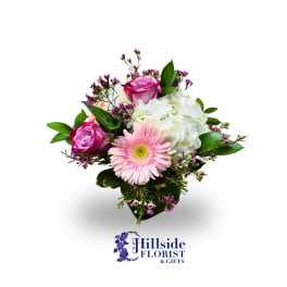 Pink gerbera daisy and roses with white hydrangea in a bouquet