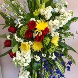 Tall mixed floral spray with red roses, yellow blooms, and white flowers