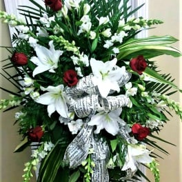 Standing sympathy spray with white lilies and red roses on a ribboned easel