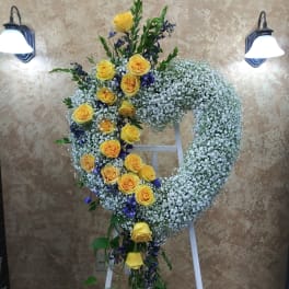 Yellow roses and white baby's breath arranged on a standing wreath