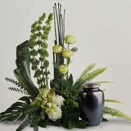 Green floral arrangement with a black urn