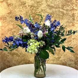 Blue and white mixed bouquet in a clear glass vase