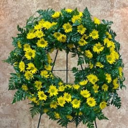 Yellow daisy wreath on a black stand