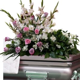 Pink and white floral spray on a silver casket