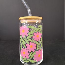 Glass tumbler with pink flower print and a clear straw