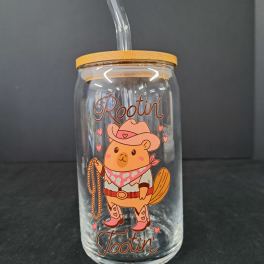 Clear glass tumbler with a straw and cowboy bear graphic