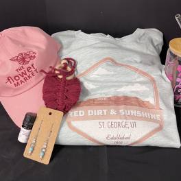 Gift set with a pink cap, T-shirt, tumbler, earrings, and a small bottle