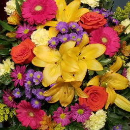 Bright mixed bouquet with yellow lilies, pink gerberas, and orange roses