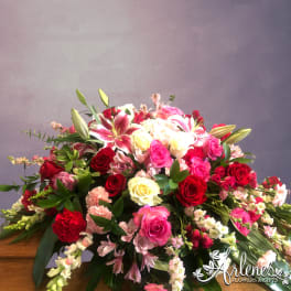 Large bouquet of red, pink, and white flowers with lilies and roses