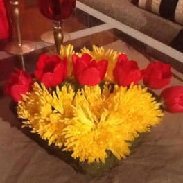Red tulips and yellow chrysanthemums arranged in a low centerpiece
