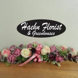 Low floral centerpiece with pink and cream roses and a pink ribbon