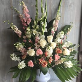 Tall floral arrangement in a white vase with pink and white blooms