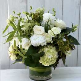 White roses and hydrangea arranged in a glass vase