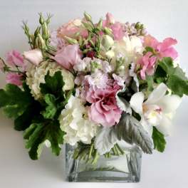 Pink and white mixed bouquet in a square glass vase