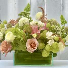 Mixed pastel bouquet in a green rectangular vase
