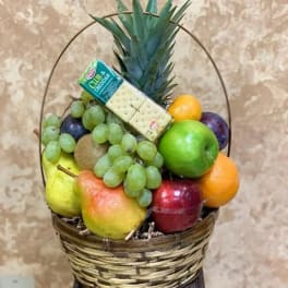 Fruit basket with grapes, apples, oranges, pears, kiwi, pineapple, and crackers