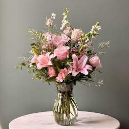 Pink mixed bouquet with lilies and roses in a clear glass vase