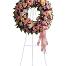 Floral wreath on a white easel with a pink ribbon bow