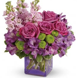 Purple roses and alstroemeria in a purple glass vase