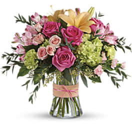 Bouquet of pink roses and lilies in a clear glass vase