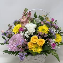 Mixed flower basket with yellow, pink, purple, and white blooms