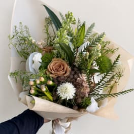Hand-tied bouquet with tan, white, and pale pink flowers