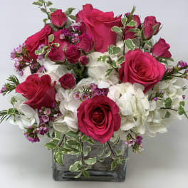 Pink roses and white hydrangeas in a square glass vase