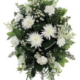 White funeral spray with daisies and carnations on a stand