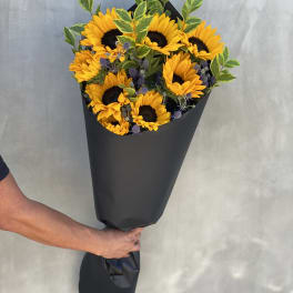 Bouquet of yellow sunflowers wrapped in black paper