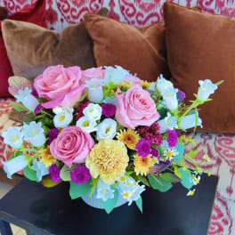Pink roses and mixed pastel flowers arranged in a white vase