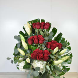 Red roses and white lilies arranged in a green vase