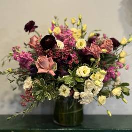 Mixed bouquet of roses and small blooms in a glass vase