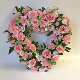 Heart-shaped floral wreath of pink roses and carnations