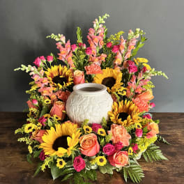 Colorful floral wreath around a white ceramic urn