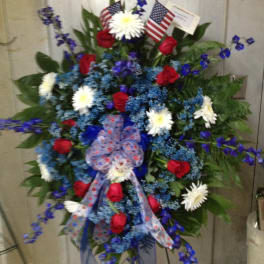 Large patriotic wreath with red, white, and blue flowers and ribbon