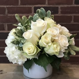 White rose arrangement in a white vase