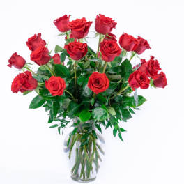 Tall bouquet of long-stemmed red roses in a clear glass vase