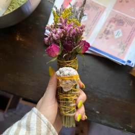 Small dried flower bundle wrapped with yellow cord and a shell accent