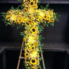 Yellow floral cross on a wooden stand