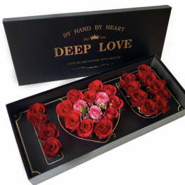 Black gift box with red and pink roses arranged in a heart shape