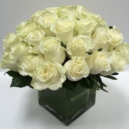 Bouquet of white roses in a square glass vase