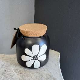 Black jar with a cork lid and white flower design