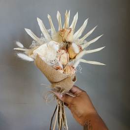 Small bouquet of dried cream roses wrapped in burlap