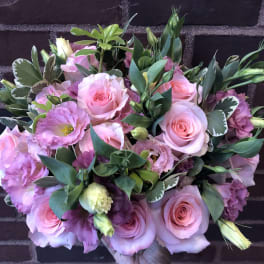 Pink roses and lisianthus bouquet with green foliage