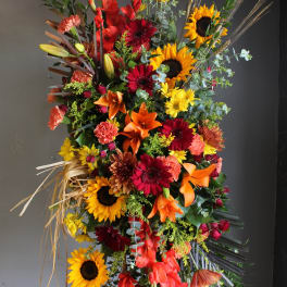 Tall floral spray with sunflowers, lilies, and red gerbera daisies