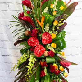 Tall tropical floral spray with red and yellow blooms on a stand