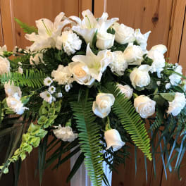 White floral spray with roses and lilies in a standing arrangement