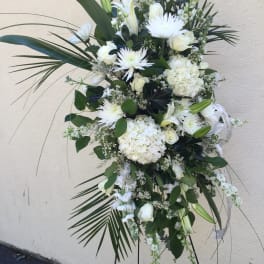 Tall white floral standing spray with roses, lilies, and hydrangeas
